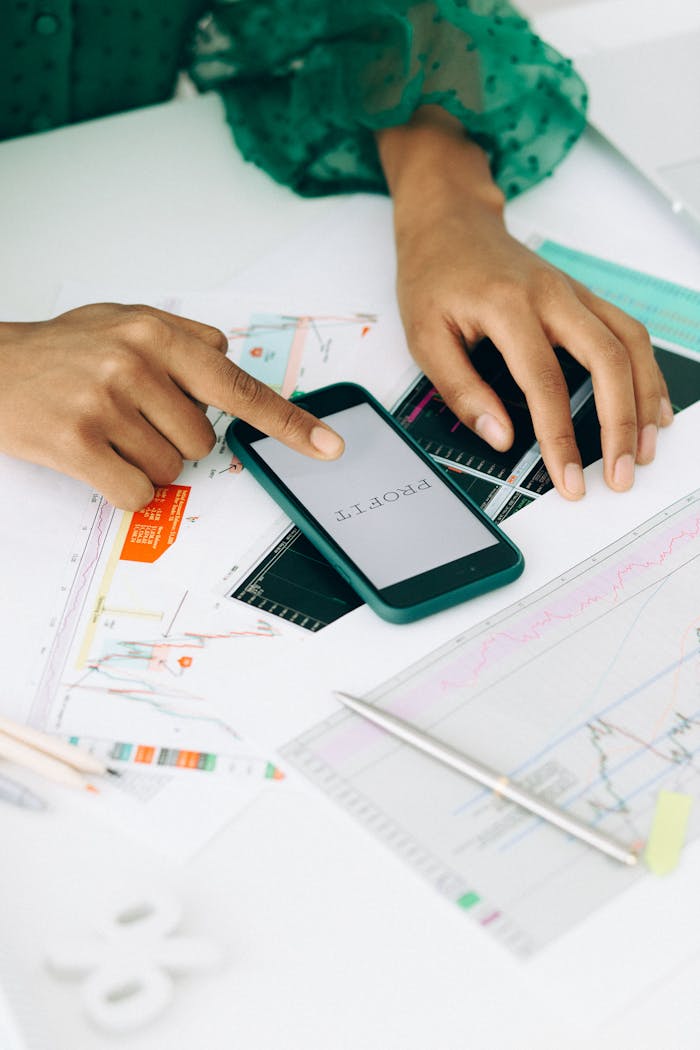 services-01 Hands analyzing financial charts using a smartphone, highlighting profit trends.
